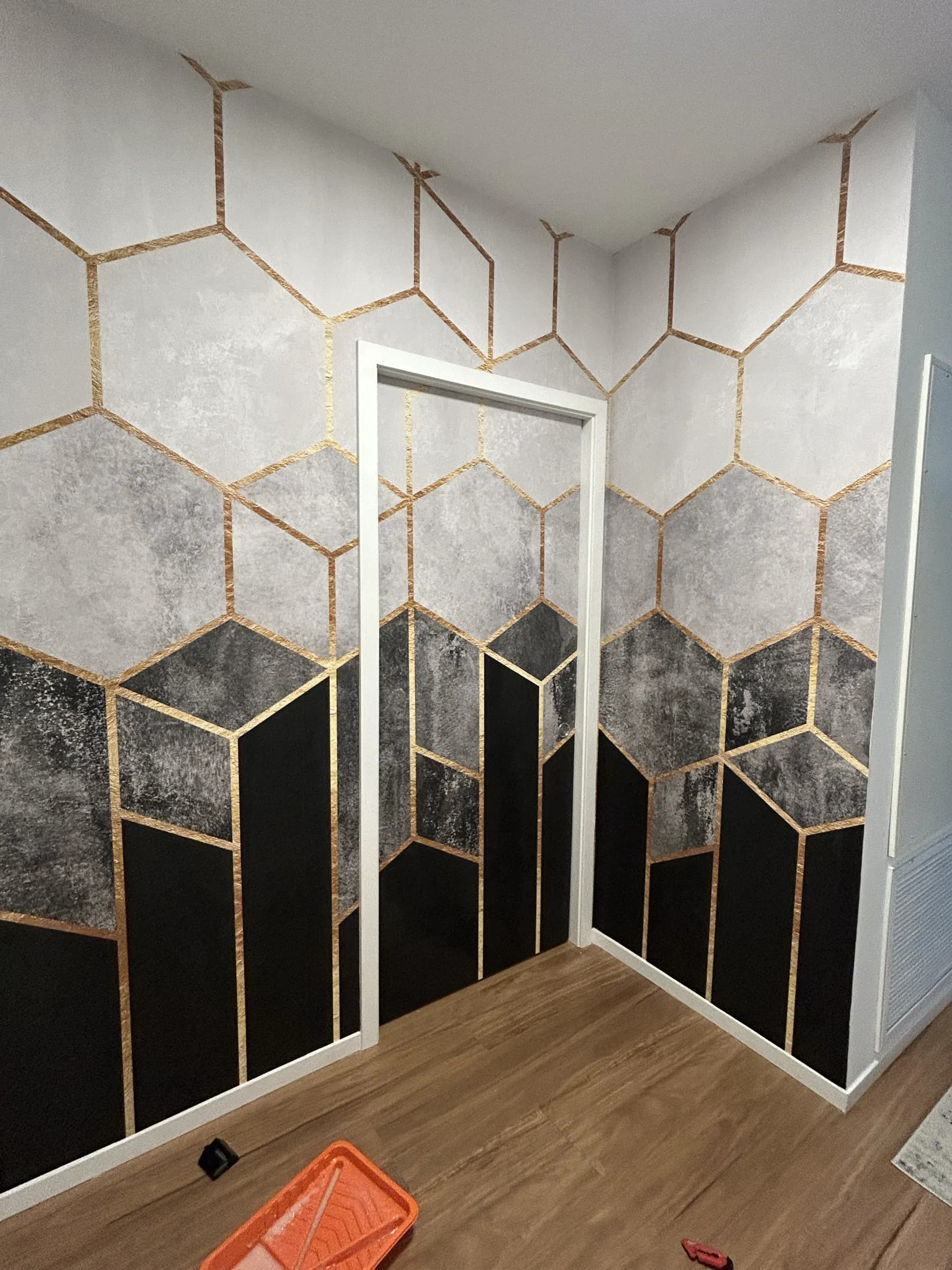 A wall of marbled hexagons outlined in gold around a doorway