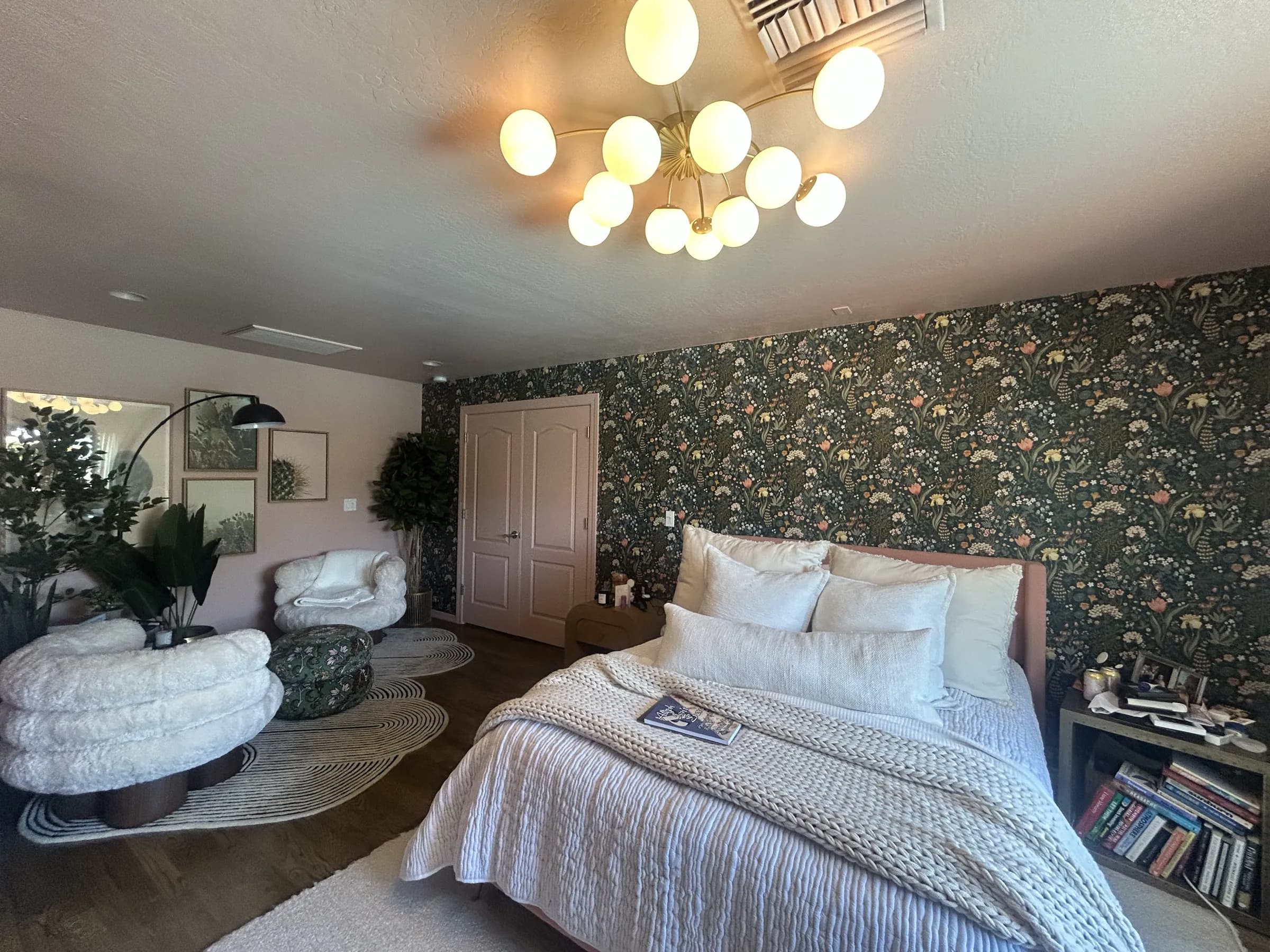 A finished bedroom with a dark botanical feature wall behind the bed